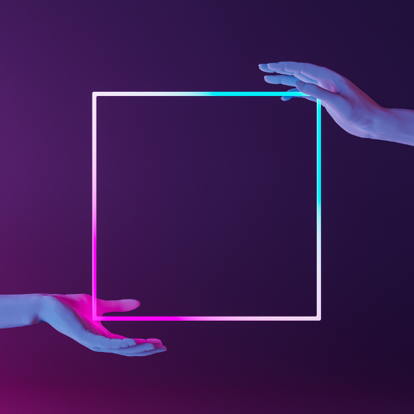 Two hands reaching toward a glowing, neon square frame against a dark, gradient purple background. OCIDM,io Branding and Digital marketing Hamilton, Toronto, Oakville, Mississauga