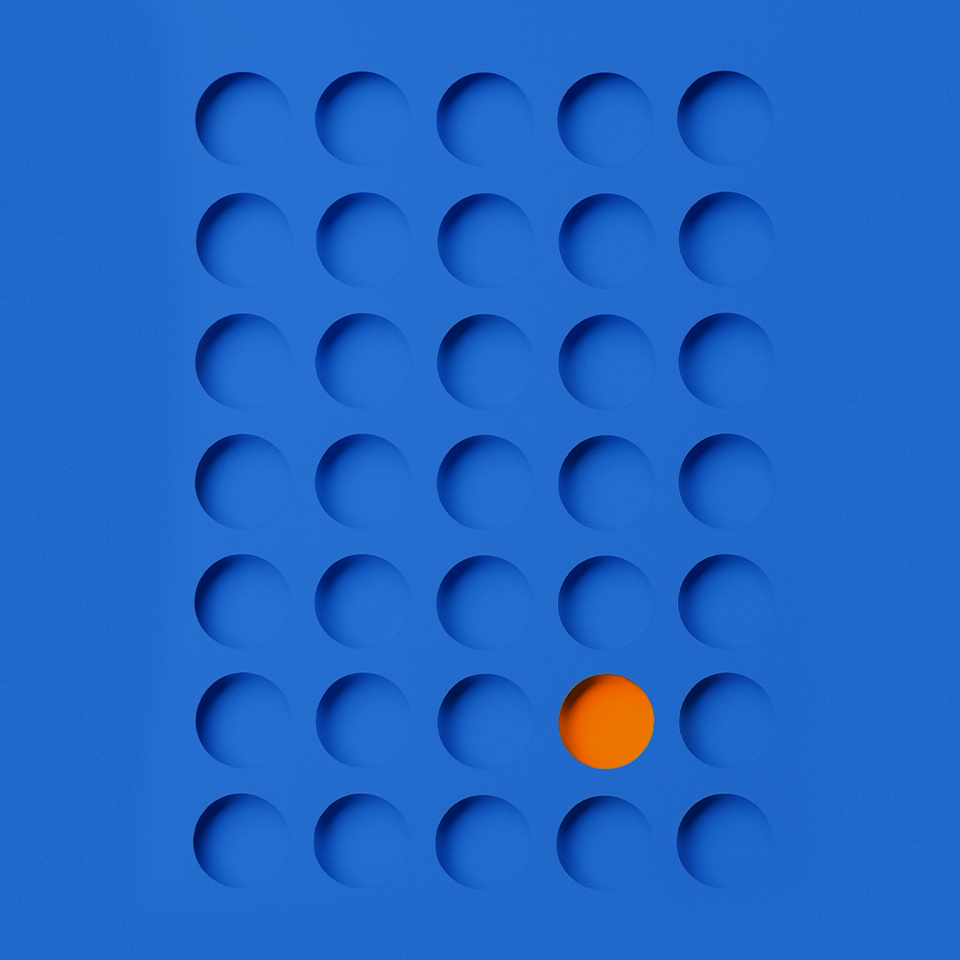 A blue grid with 5x5 round indentations, with one orange sphere placed in the fourth row and third column. OCIDM,io Branding and Digital marketing Hamilton, Toronto, Oakville, Mississauga