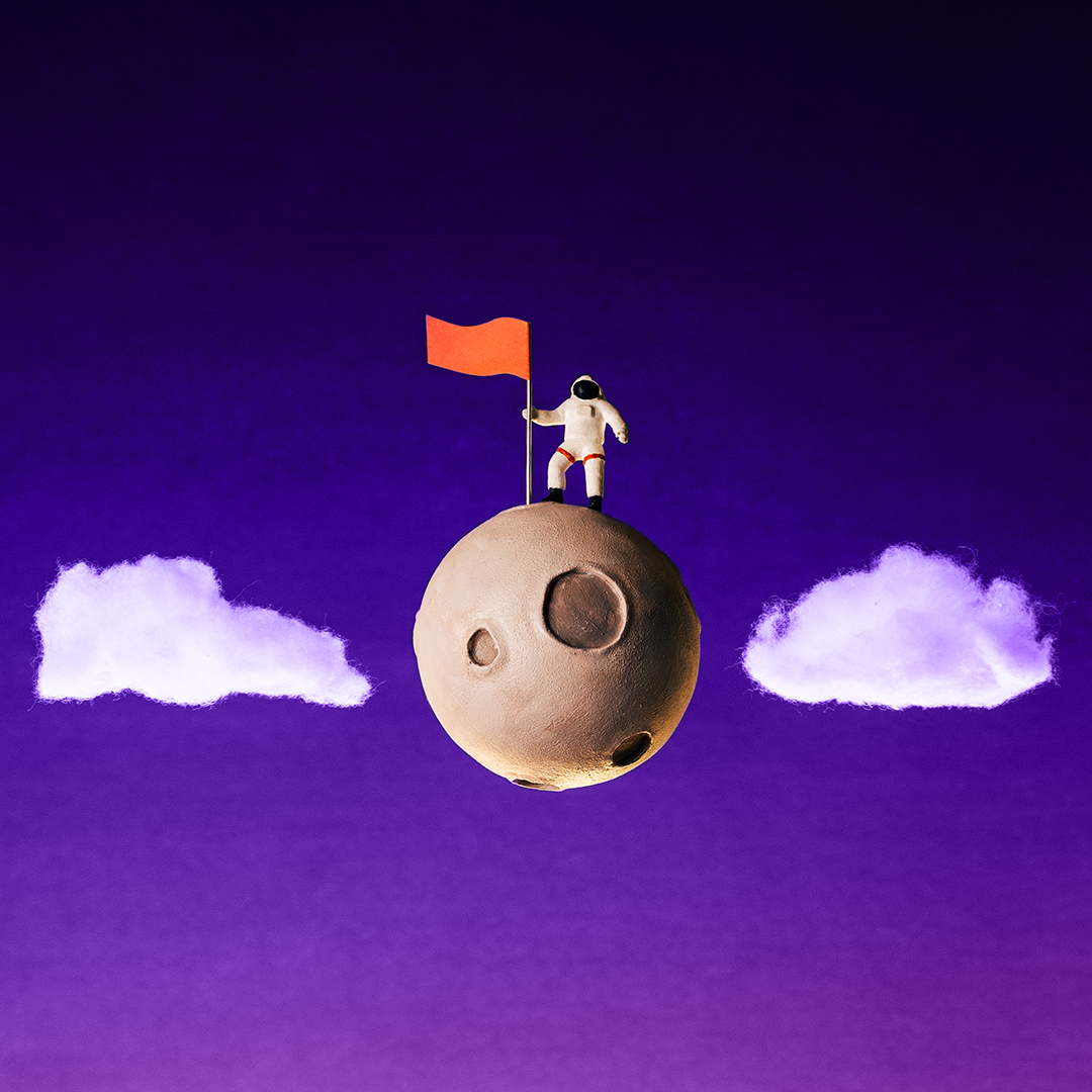 An astronaut stands on a small planet holding a red flag, with two fluffy clouds on either side against a deep purple background. OCIDM,io Branding and Digital marketing Hamilton, Toronto, Oakville, Mississauga