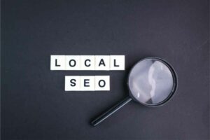 The words "Local SEO" spelled with letter tiles next to a magnifying glass on a black background, symbolizing the rebranding strategy for dentists focusing on practice growth. OCIDM,io Branding and Digital marketing Hamilton, Toronto, Oakville, Mississauga