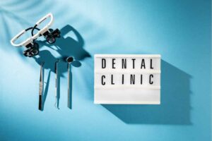 Dental tools and a sign reading "Dental Clinic" on a blue background, symbolizing the rebranding efforts essential for dentists focusing on practice growth. OCIDM,io Branding and Digital marketing Hamilton, Toronto, Oakville, Mississauga